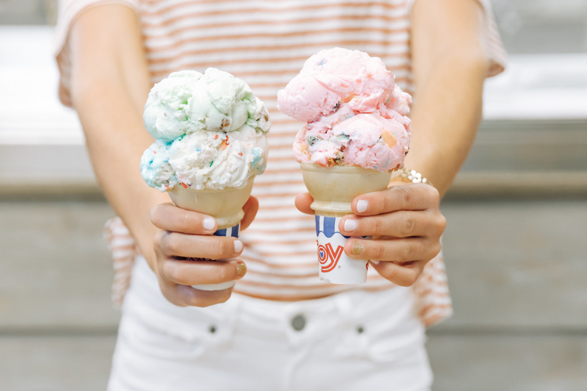 Striped shirt, white jeans and two ice cream cones that are pink and green